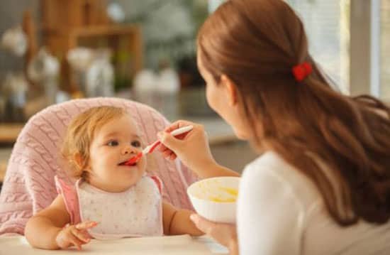 mother feeding baby baby food